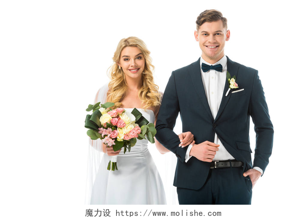 在白色背景墙下一对恩爱的小夫妻看着镜头在甜蜜的微笑幸福的新娘与婚礼花束, 和微笑的新郎在黑色西装孤立在白色